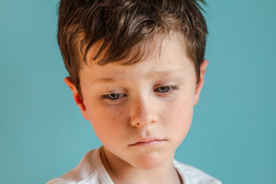 Sad boy looking down in studio
