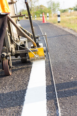 Machine eject and worker on road and traffic sign painting