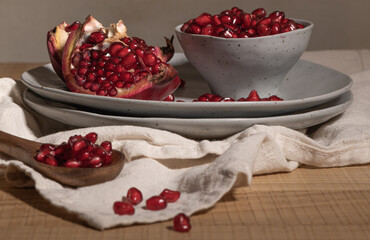 Delicious ripe pomegranate kernels in ceramic bowl on kitchen countertop. Space for text