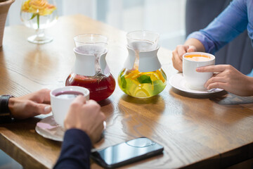 Two women discuss business projects in a cafe over hot lemonade or herbal tea. coffee shop or restaurant concept 