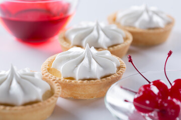 Close-up of a shortbread basket with cream and cherries. Production of pastries and cakes.