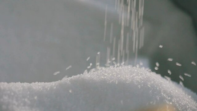 Polypropylene granules. Falling polypropylene granules, slow motion. Polypropylene granules close-up. Nonwoven Fabric Factory