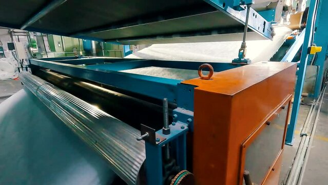 Synthetic winterizer on the conveyor line, close-up. Factory for the production of non-woven materials. Production of synthetic winterizer close-up. Syntepon manufacturing process