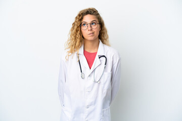 Fototapeta premium Young doctor blonde woman isolated on white background and looking up