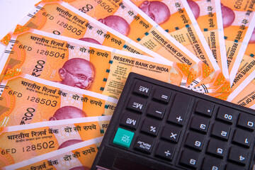 Success and got profit from business with new series of 200 indian rupee currency,money and calculator isolated on white background.