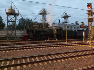 Fototapeta na wymiar steam locomotive on rails at dry morning