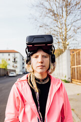 Young nonconformist diverse woman outdoor putting off 3D goggles back to real life