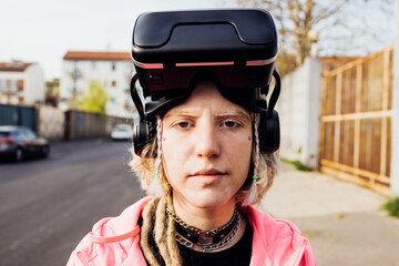 Portrait young woman outdoor putting off 3D headset after gaming in metaverse