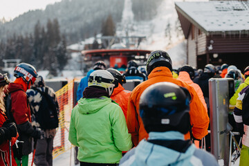 01.03.2021 Bukovel, Ukraine: Queues of people dressed in ski equipment near the lifts on the mountain in the tourist town