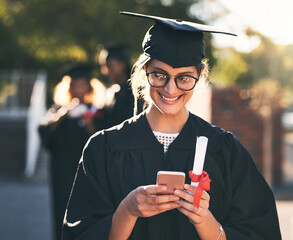 Status update Guess who just graduated. Shot of a young woman using a mobile phone on graduation...