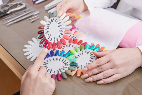 Woman at nail studio chosing color of nail polish. High quality photo