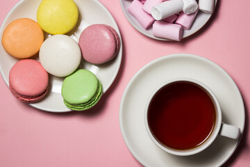 Cup of tea and sweets on a pink background. Sweet breakfast. Natural brewed tea