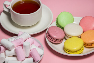 Cup of tea and sweets on a pink background. Sweet breakfast. Natural brewed tea