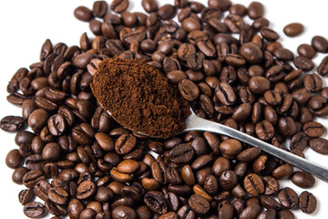 A spoon of ground coffee next to coffee beans on a white background. Roasted coffee beans. tonic drink