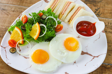 breakfast in a marble plate There are sandwiches, fried eggs, salad.