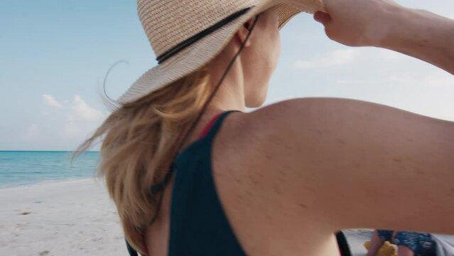 Woman in straw hat relaxes on the beach