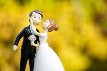 cake topper raffiguranti gli sposi in miniatura su sfondo giallo 