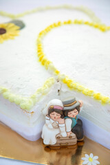 cake topper raffiguranti gli sposi in miniatura  vicino alla torta