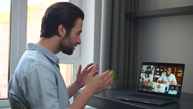 Caucasian man using laptop for video connection with friends. Man talking with young people on the screen. Video chatting concept. 4K footage