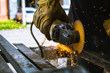 mano de trabajador cortando y puliendo metal con herramienta de construcción 