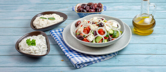 Fototapeta na wymiar Greek salad with tzatziki, olives and feta cream. Traditional salad, meze, with olive oil