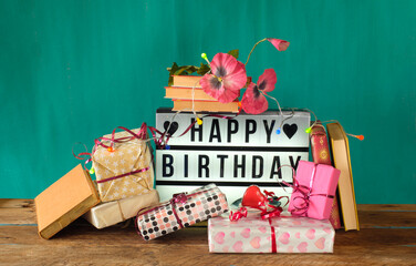 gift-wrapped books as birthday present, sign with lettering happy birthday and decoration....