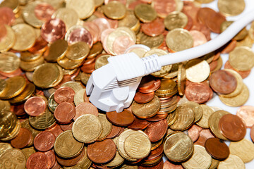 White european electricity power plug lying in Heap of Euro money coins. Concept of saving...