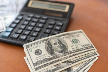 Fototapeta premium Money and calculator on wooden table.