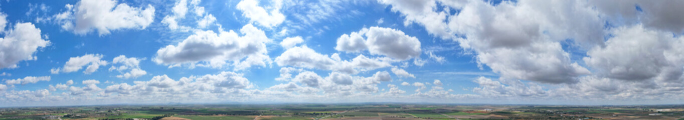 Naklejka na ściany i meble Impressive panoramic shot of the horizon with a great blue sky with clouds