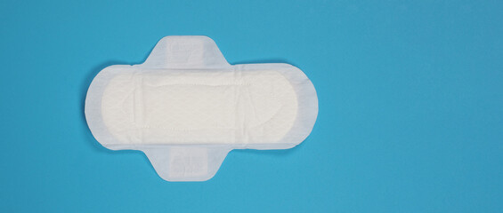 Woman sanitary napkins on blue background. Top view. Absorbent pads worn by women to absorb menstrual blood. Comfortable white sanitary napkins arranged on light blue paper. Represent Hygiene concept - obrazy, fototapety, plakaty