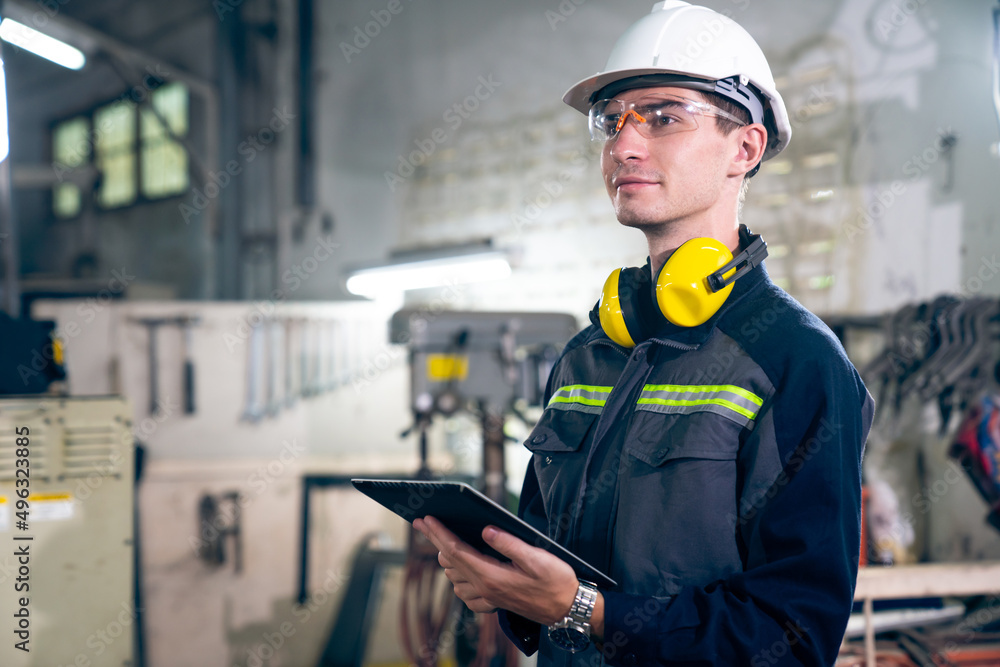 Poster young factory worker using adept tablet computer in a workshop building . industrial technology and 