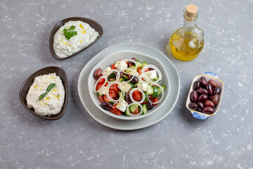 Fototapeta na wymiar Greek salad with tzatziki, olives and feta cream. Traditional salad, meze, with olive oil