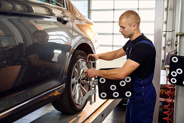 Аuto mechanic sets the car for diagnostics and configuration collapse-convergence. Car Wheels...