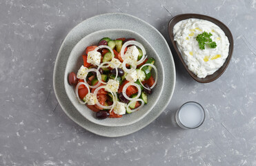 Traditional drink Ouzo or Raki and traditional greek salad, tzatziki and olives