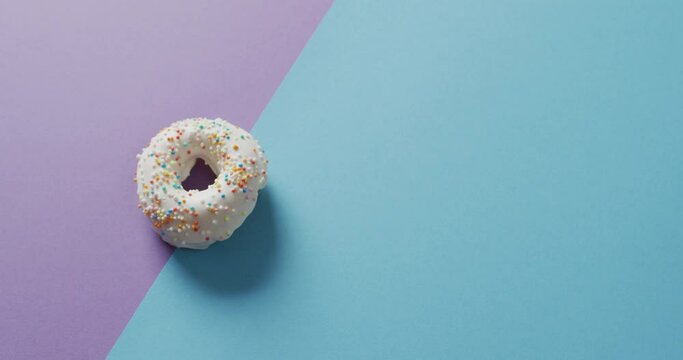 Video of donut with icing on purple and blue background