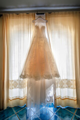 abto da sposa appeso in camera,  pronto per essere indossato il giorno del matrimonio