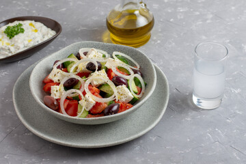 Traditional drink Ouzo or Raki and traditional greek salad, tzatziki and olives