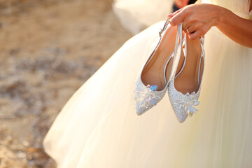 Dettaglio di décolleté tenute in mano da una sposa