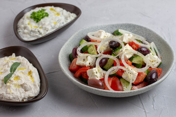 Greek salad with feta cheese,  tzatziki, olives and feta cream. Traditional salad, meze,  with olive oil, top view