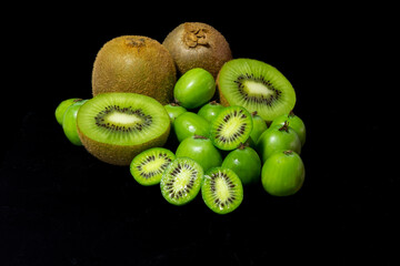 Detail of kiwis of different varieties, Green Kiwi and Baby Kiwi with black background