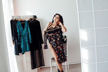 a beautiful woman in the fitting room looks in the mirror with clothes