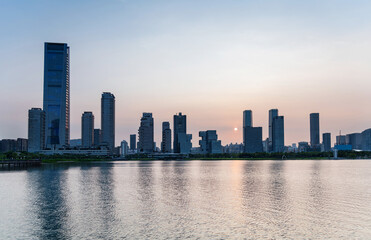 Fototapeta premium Office building reflected in the water at sunset