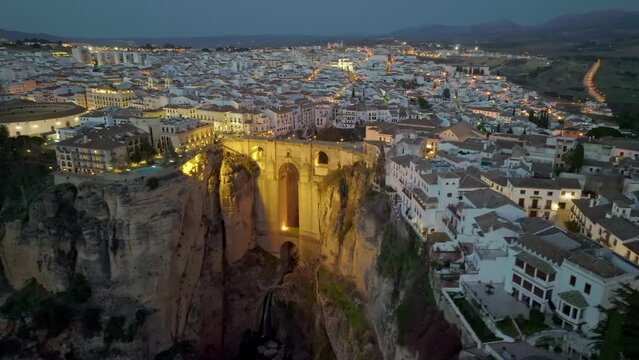 Flying over Ronda and Puente Nuevo Bridge after sunset. Evening aerial view of Ronda, Spain