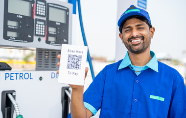 rack focus shot of petrol pump worker showing scan here to pay qr code for payment by looking at...