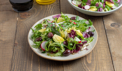 Green vegan salad from green leaves mix vegetables and olives. 