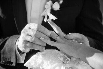 foto in bianco e nero dello scambio delle fedi tra due sposi 
