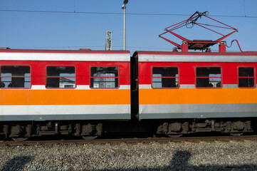 Obraz premium side of red electric train on the railway