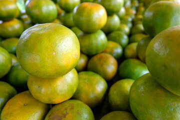 Neatly organised piles of local freshly picked citrus oranges at a fruit and vegetable market stall in Dili, Timor Leste