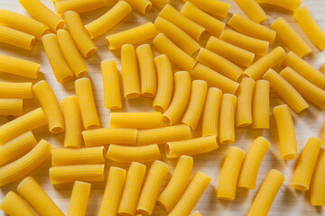 Top view raw macaroni as background, close up. Italian macaroni pasta on a white table for branding, calendar, postcard, wallpaper, poster, banner, cover, website. A place for your design or text