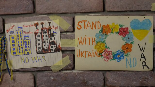 Ukrainian children's drawings for peace against the 2022 Russian Invasion of Ukraine are placed on the brick wall in a bomb shelter